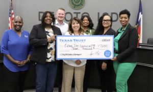 Group of people holding large check